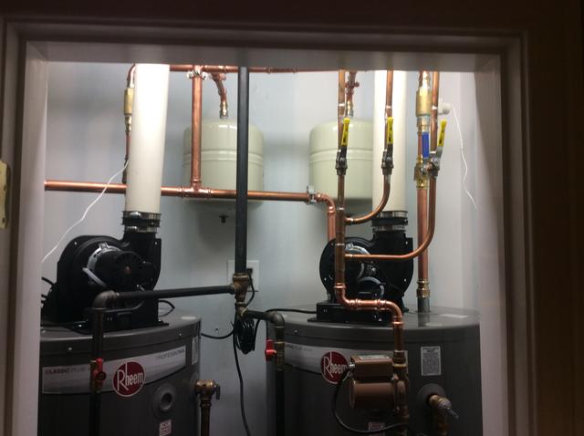 two new water heaters installed in a utility closet